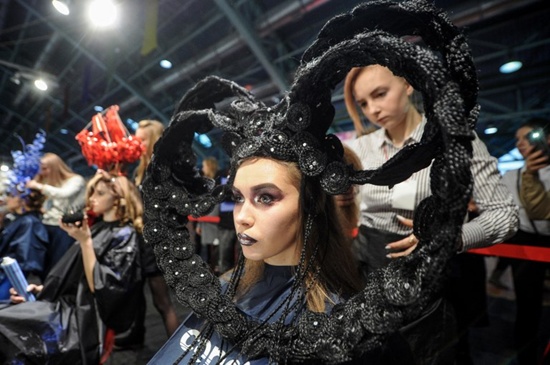 A stylist works on a model during a hairstyling competition in Minsk on November 9, 2017. Sergei Gapon/AFP