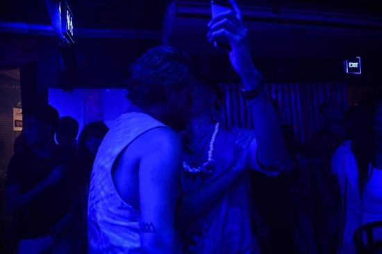This photograph taken on October 8, 2017 shows a gay Chinese tourist (L) kissing another reveller at ZAG bar in Thailands southern tourist destination of Phuket. Lillian Suwanrumpha/AFP