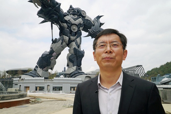 Chen Jianli, chief executive officer of Oriental Science Fiction Valley theme park, is pictured during an interview with Reuters in front of a giant robot statue at the park in Guiyang, Guizhou province, China November 16, 2017. Picture taken November 16, 2017. REUTERS/Joseph Campbell