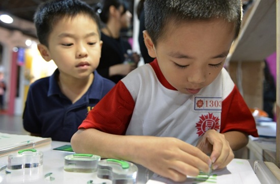 This picture taken on October 20, 2017 shows a boy stamping a Chinese character during an exhibition in Taipei. Sam Yeh/AFP