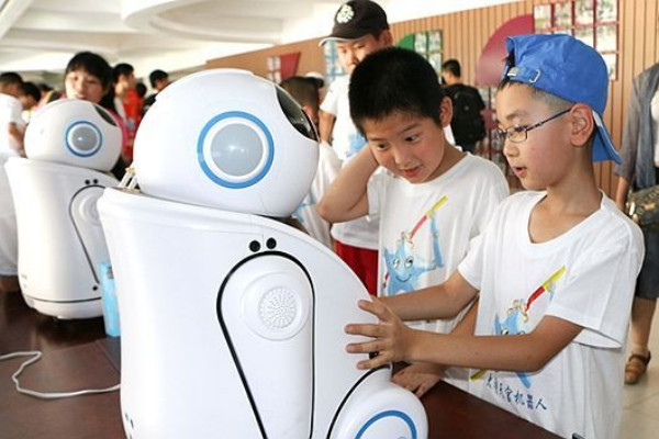 เด็กประถมจีนกำลังเพลิดเพลินกับเหล่าหุ่นยนต์ปัญญาประดิษฐ์ (ภาพจาก china.com.cn)