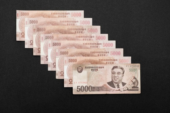 This photo illustration shows a selection of North Korean 5,000 won currency bank notes featuring the image of late North Korean leader Kim Il-Sung, issued by Pyongyang and displayed in Seoul on January 4, 2018. Ed Jones/AFP