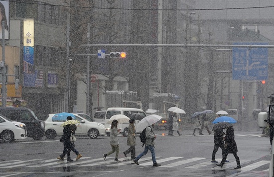 People walk on a crossing in Tokyo, Monday, Jan. 22, 2018. (AP Photo/Shizuo Kambayashi)
