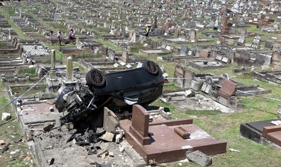 A Mercedes SUV lies amongst the gravestones at a cemetery in the Sydney suburb of South Coogee on February 6, 2018. William West/AFP