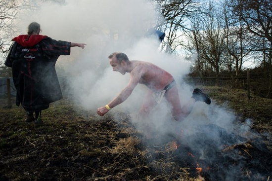 A competitor leaps over a fire as he participates in the Tough Guy endurance event near Wolverhampton, central England, on February 4, 2018. Oli Scarff/AFP