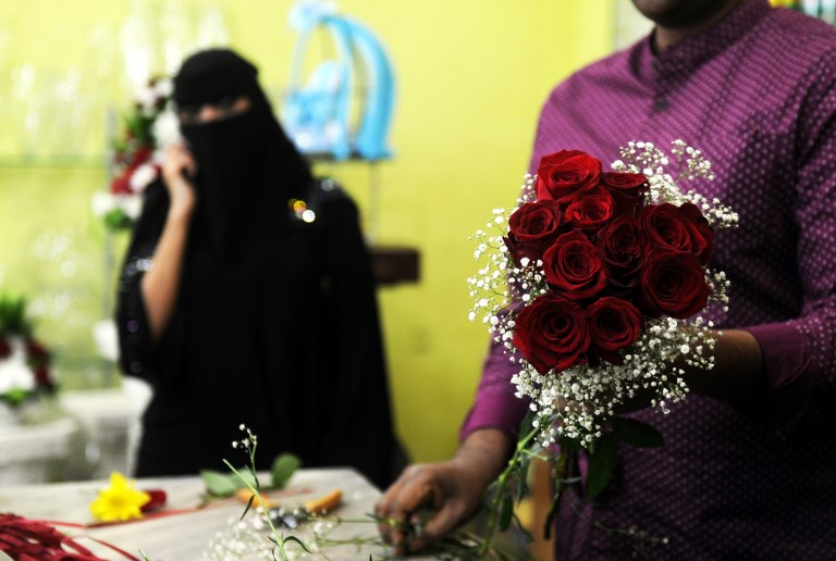เจ้าของร้านขายดอกไม้ในนครเจดดาห์กำลังจัดช่อดอกกุหลาบแดงให้แก่ลูกค้าชาวซาอุฯ เมื่อวันที่ 14 ก.พ. 