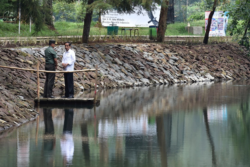 ประธานาธิบดี โจโค วิโดโด แห่งอินโดนีเซียพูดคุยกับผู้บัญชาการทหารส่วนภูมิภาค ขณะเดินทางไปตรวจเยี่ยมทะเลสาบจิซันตี (Lake Cisanti) ทางตอนใต้ของเมืองบันดุง ซึ่งเป็นต้นน้ำของแม่น้ำจิตารุม (Citarum River) เมื่อวันที่ 22 ก.พ.