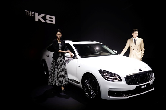 Models pose for photographs with Kia Motors new flagship sedan The K9 during its unveiling ceremony in Seoul, South Korea, April 3, 2018. REUTERS/Kim Hong-Ji