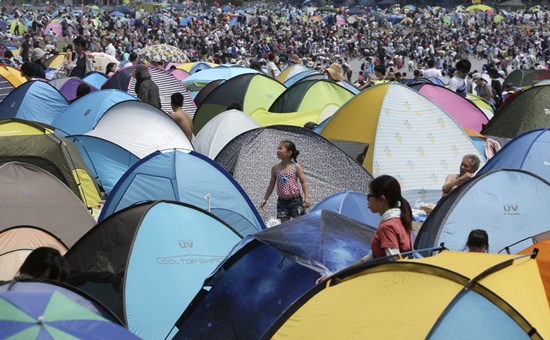 Holiday makers, seen over tents, come to the beach to hunt for clams in Yokohama, near Tokyo, Monday, April 30, 2018. (AP Photo/Koji Sasahara)
