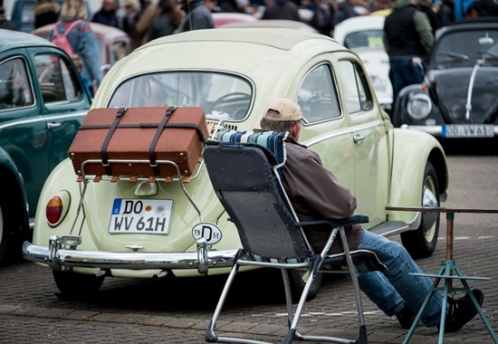 A man sits next to his vintage beetle during the 35th May Beetle meeting in Hanover, on May 1, 2018. Peter Steffen/dpa/AFP