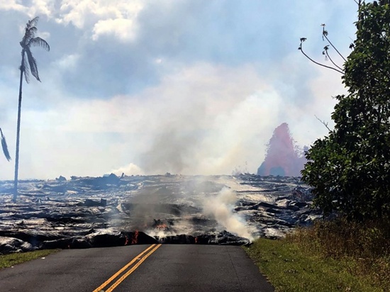 This image released by the US Geological Survey (USGS), shows lava advancing west from fissure 7 with a lava fountain in the background on Leilani Avenue at Leilani States, on May 27, 2018. Fissure 7 activity increased overnight, with lava fountains reaching 50 to 60 meters (164 to 197 feet) high. Handout/US Geological Survey/AFP