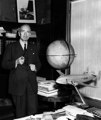 French aircraft designer Louis Charles Breguet poses in his office near a model of the plane F-BASN and a globe, in the 50s. AFP