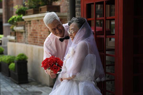 นาย เฉิน กัวจื้อ วัน 85 ปี และภรรยาวัย 82 ปี ในชุดเจ้าบ่าวเจ้าสาว ถ่ายภาพในงานฉลองการแต่งงานหมู่ของกลุ่มผู้สูงอายุ ที่ครองรักยั่งยืนมากกว่า 50 ปี ในนครเทียนจิน วันที่ 16 ส.ค. ก่อนวันแห่งความรักตามประเพณีชนชาติจีน ที่ชาวจีนเรียก ชีซี (ภาพ รอยเตอร์ส)