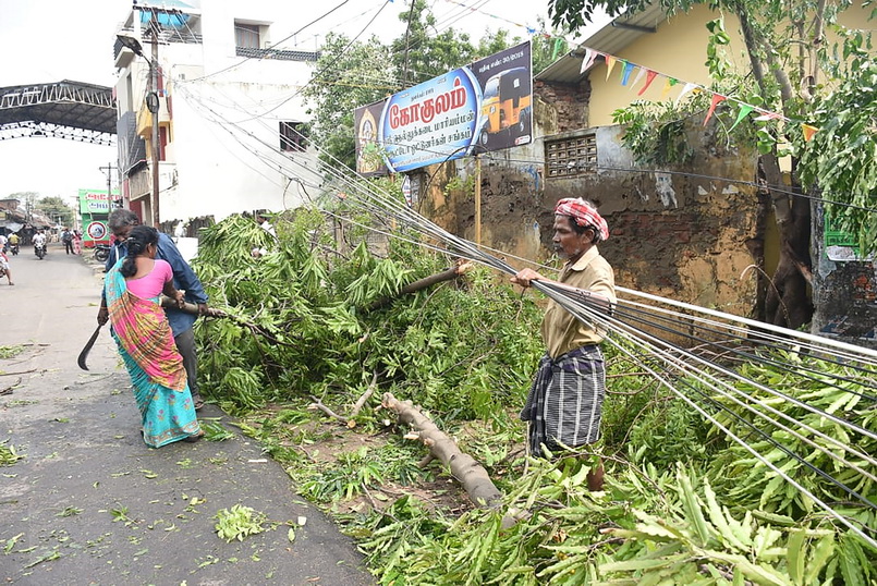 ประชาชนช่วยกันเคลื่อนย้ายต้นไม้ที่หักโค่นขวางถนนใกล้สถานีรถไฟในเมืองนากาปัตตินัม รัฐทมิฬนาฑู หลังพายุไซโคลนคชะ (Gaja) ซัดถล่มเมื่อช่วงเช้าที่ผ่านมา (16 พ.ย.) 
