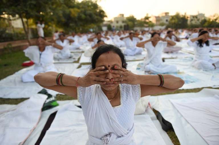 ภาพกิจกรรมโยคะที่อินเดีย ทั้งนี้มีความเชื่อว่าการออกกำลังกายช่วยลดโอกาสเป็นอัลไซเมอร์ (SAM PANTHAKY / AFP) 
