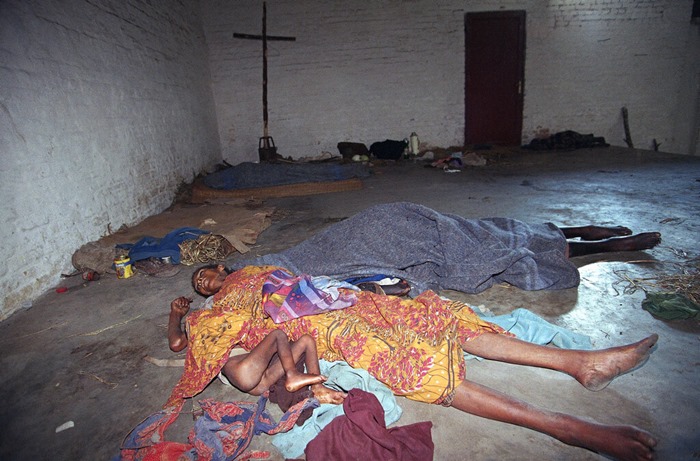 &lt;i&gt;(ภาพจากแฟ้มถ่ายเมื่อ 8 มิ.ย. 1994) เด็กหญิงผู้หนึ่งกอดศพแม่ของเธอ ซึ่งเสียชีวิตไปเมื่อ 2 วันก่อนเนื่องจากอดอาหาร ภายในโรงสวดของโรงเรียนศาสนา ที่เมืองคับกายี ซึ่งชาวทุตซี่พลัดที่อยู่เข้าไปอาศัย  พวกกบฏสังกัดแนวร่วมอาร์พีเอฟ พบแม่ลูกคู่นี้ภายหลังยึดเมืองนี้ได้จากกองกำลังรัฐบาล โดยพวกผู้รอดชีวิตบอกว่าใช้สถานที่แห่งนี้เป็นค่ายกักกันชาวทุตซี่ &lt;/i&gt;