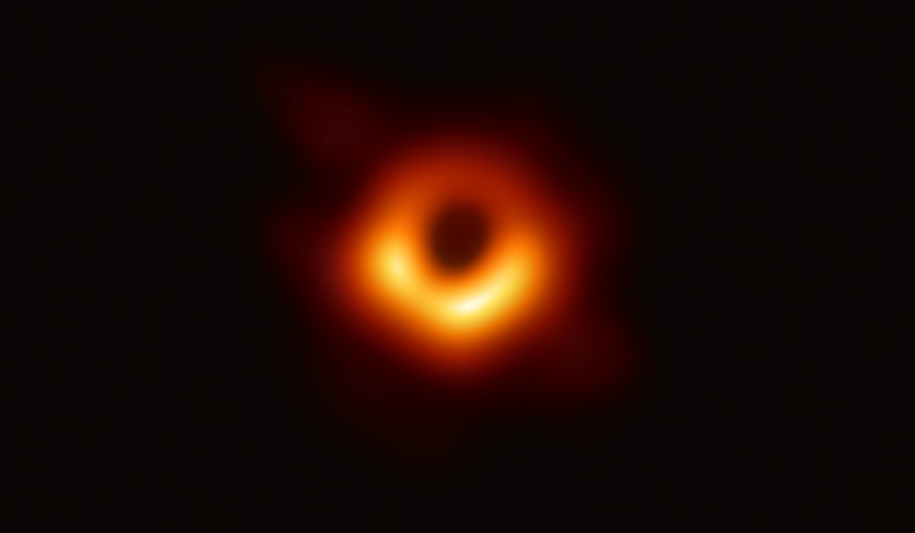 ภาพนี้แสดงให้เห็นถึงวงแสงที่โค้งตามความโน้มถ่วงรอบหลุมดำซึ่งมีมวลมากกว่าดวงอาทิตย์ 6.5 พันล้านเท่า เป็นหลักฐานชิ้นสำคัญที่แสดงถึงการมีอยู่ของหลุมดำมวลยวดยิ่ง และเปิดหน้าต่างบานใหม่ในการศึกษาหลุมดำ ขอบฟ้าเหตุการณ์ และความโน้มถ่วง  (EUROPEAN SOUTHERN OBSERVATORY / AFP )