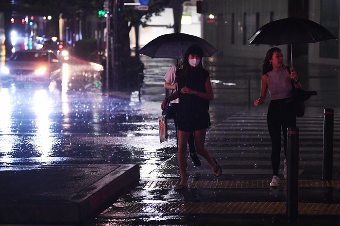 <i>ผู้คนข้ามถนนในกรุงโตเกียวท่ามกลางสายฝนเมื่อคืนวันอาทิตย์ (8 ก.ย.)  ขณะไต้ฝุ่น “ฟ้าใส” เคลื่อนใกล้เข้ามา </i>