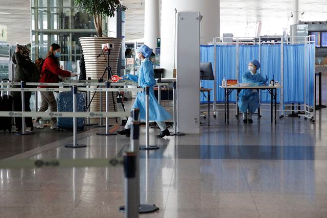 เจ้าหน้าที่ตรวจเช็คสุขภาพผู้โดยสารที่สนามบินนานาชาตินครหลวงปักกิ่ง ภาพ 16 มี.ค.2020 (ภาพรอยเตอร์ส)