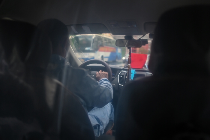 &lt;i&gt;คนขับแท็กซี่สวมชุดป้องกันโรค แล้วยังมีแผ่นพลาสติกกั้นระหว่างตัวเขากับผู้โดยสาร เพื่อเป็นมาตรการป้องกันการระบาดของโควิด-19  ขณะขับรถแท็กซี่ของเขาอยู่ในเมืองอู่อัน วันอาทิตย์ (29 มี.ค.) &lt;/i&gt;