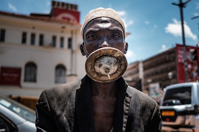 ชายใส่หน้ากากทางเลือกยืนถ่ายรูปในกรุงกัมปาลาของยูกันดา