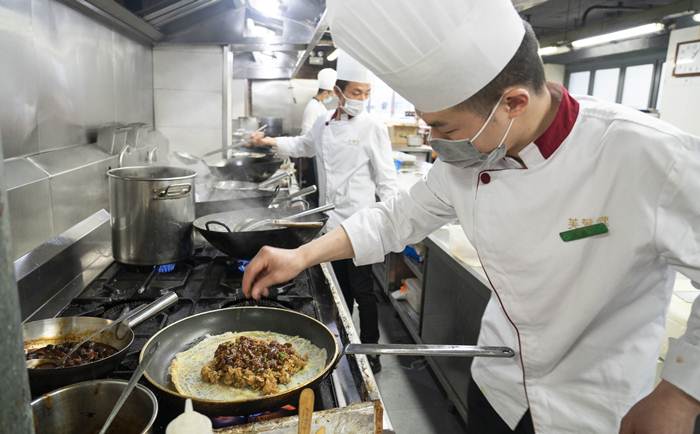 พ่อครัวในร้านอาหารแห่งหนึ่ง ในนครอู่ฮั่น มณฑลหูเป่ยทางตอนกลางของจีน เมื่อวันที่ 2 เม.ย. 2020 --ภาพซินหัว 