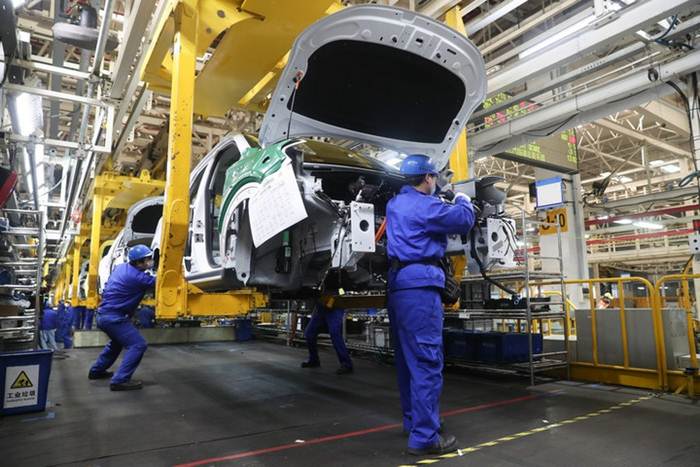 แฟ้มภาพซินหัว : พนักงานปฏิบัติงานในโรงงานของเอสเอไอซี มอเตอร์ ผู้ผลิตรถยนต์ชั้นนำของจีน ในเขตพิเศษหลินก่าง นครเซี่ยงไฮ้ทางตะวันออกของจีน วันที่ 27 ก.พ. 2020