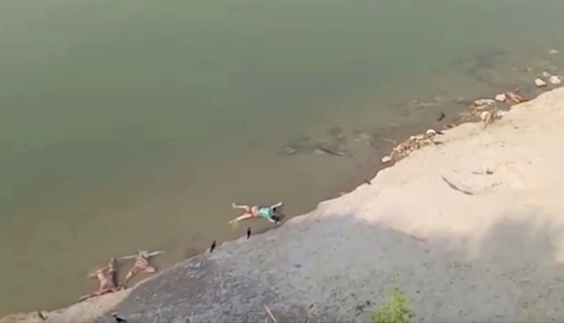 ภาพที่ถ่ายจากวิดีโอของ เคเค โปรดักชั่นส์ แสดงให้เห็นศพที่ลอยมาเกยตลิ่งริมแม่น้ำคงคา ในอำเภอกาซิปุระ รัฐอุตตรประเทศ ของอินเดีย เมื่อวันอังคาร (11 พ.ค.)