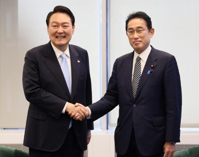 นายกรัฐมนตรีญี่ปุ่น ฟูมิโอะ คิชิดะ (ขวา) และประธานาธิบดีเกาหลีใต้ ยุน ซอกยอล จับมือกันระหว่างพบกันที่นิวยอร์กเมื่อวันที่ 21 กันยายน พ.ศ.2565 (ภาพโดยสำนักงานกิจการสาธารณะของคณะรัฐมนตรีของญี่ปุ่น) (เกียวโด)