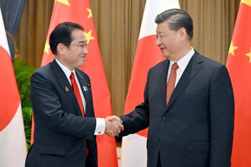 นายกรัฐมนตรีฟูมิโอะ คิชิดะ ของญี่ปุ่น (ซ้าย) และประธานาธิบดีสี จิ้นผิง ของจีน จับมือกันก่อนที่จะมีการพูดคุยที่กรุงเทพฯ ในวันที่ 17 พ.ย.2565 (ภาพเกียวโด)