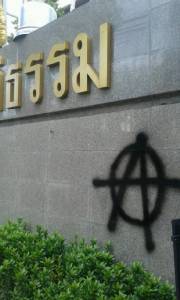 มือมืดท้าอำนาจรัฐฉีดสเปรย์ “A” หน้าป้ายศาลอาญา แสดงสัญลักษณ์ อนาธิปไตย