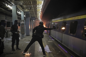 &lt;i&gt;นักศึกษาสวมหน้ากากผู้หนึ่งขว้างระเบิดขวดน้ำมันเข้าไปภายในขบวนรถไฟ ซึ่งจอดอยู่ภายในสถานีรถไฟใต้ดิน “ไชนีส ยูนิเวอร์ซิตี้” ในฮ่องกงเมื่อวันพุธ (13 พ.ย.) &lt;/i&gt;