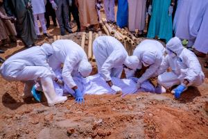 กลุ่มเจ้าหน้าที่ในชุดป้องกันกำลังฝังศพ อับบา คยารี หัวหน้าคณะทำงานประธานาธิบดีไนจีเรีย .มูฮัมมาดู บูฮารี ที่เสียชีวิตในวันศุกร์(17 เม.ย) จากโรคโควิด-19 ที่สุสานกูดูในกรุงอาบูจา ภาพประจำวันเสาร์(18 เม.ย)รอยเตอร์