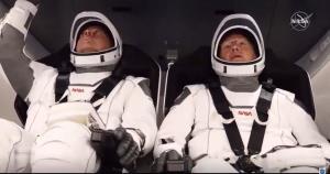  (ซ้าย) โรเบิร์ต เบห์นเกน (Robert Behnken) และ (ขวา) ดักลาส เฮอร์ลีย์ (Douglas Hurley) ในแคปซูลดรากอน (Crew Dragon spacecraft) ที่อยู่ด้านบนจรวดฟอลคอน 9 (Falcon 9) ณ ฐานปล่อยจรวด (NASA TV / AFP) 