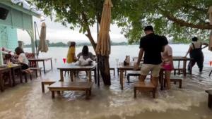 ร้านอาหารริมเจ้าพระยาเผยภาพลูกค้าสู้ไม่ถอย นั่งกินอาหาร เท้าแช่น้ำพร้อมคลื่นซัด (ชมคลิป)