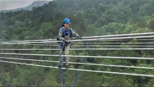 สื่อหมิงจวินออกเดินบนสายส่งไฟฟ้าที่ระดับความสูง 80 เมตร (ภาพจาก sohu.com)