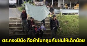 ชื่นชม! ตร.กรงปินังถือผ้าใบคลุมกันฝนให้เด็กน้อยขณะเดินข้ามถนน