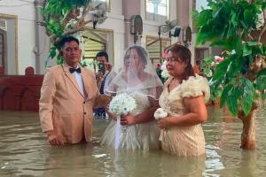 ไม่มีอะไรขัดขวางได้ คู่รักฟิลิปปินส์ลุยน้ำท่วมสูงระดับเอวเข้าพิธีวิวาห์